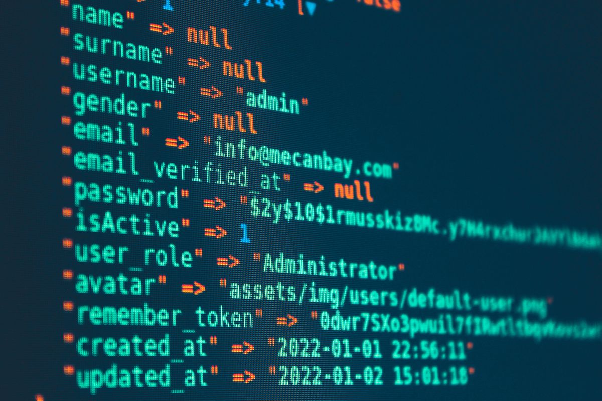SaaS database migration zero-downtime — SQL migration code on a monitor in a dark development environment