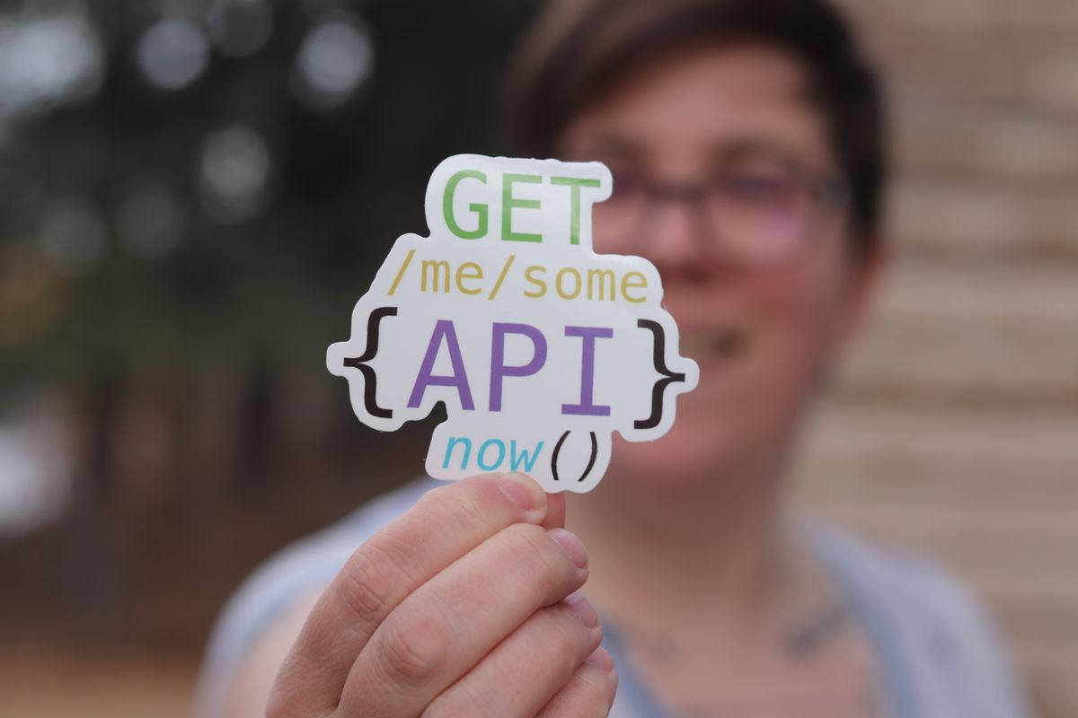 Third-party API integration reliability patterns — a hand holding a colorful API sticker representing external service integration