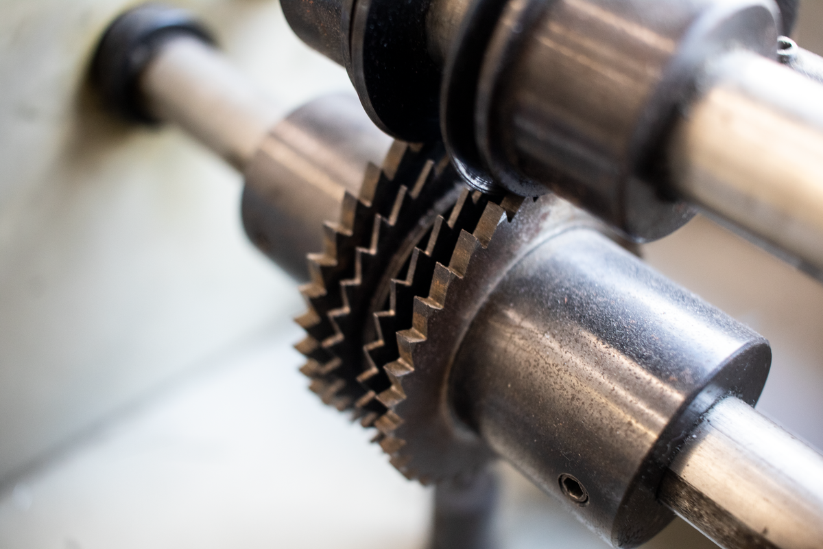 Detailed close-up of interlocking metal gears, representing Prisma's migration history and the real database schema being brought back into sync