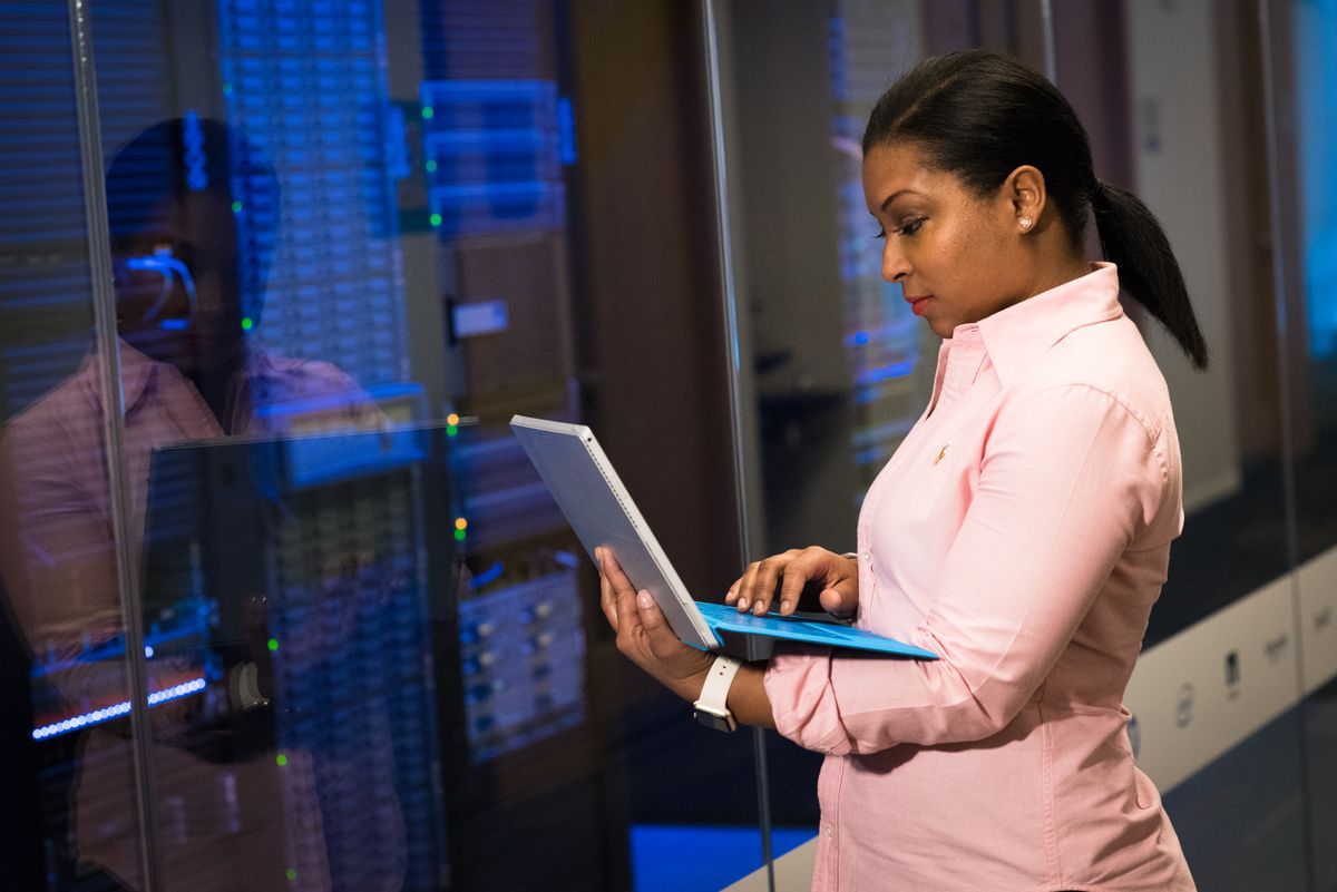 A software engineer working in a server room, representing an always-on backend host