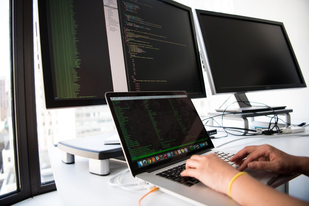Developer comparing NextJS App Router and Pages Router implementations on dual monitors