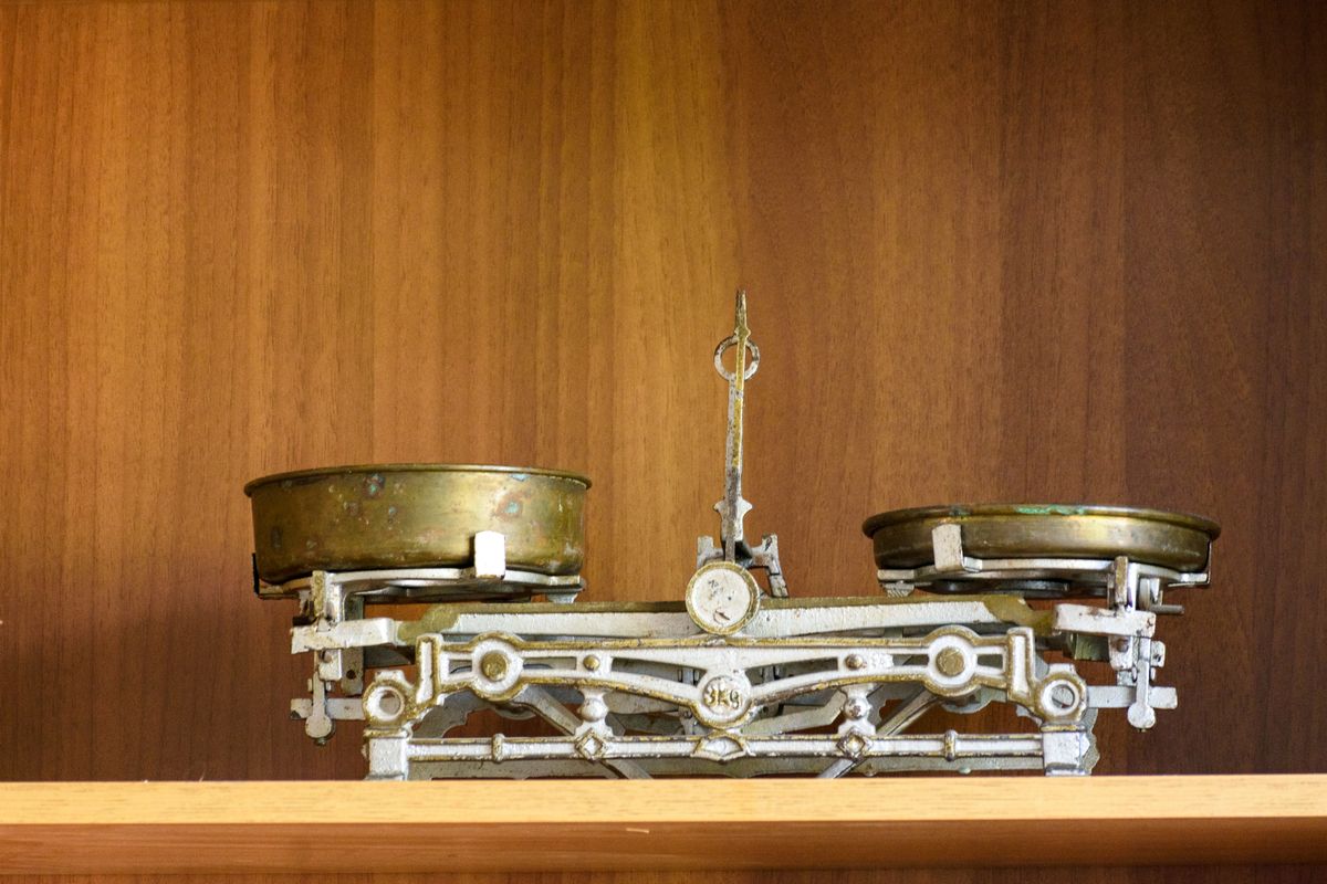 A vintage brass balance scale with two pans, weighted evenly against each other, representing the tradeoff between the simplicity of skipping optimization and the extra setup of a custom loader