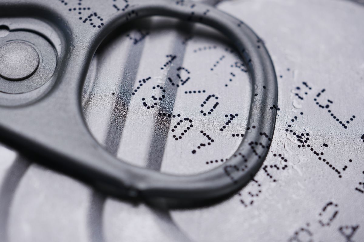 A close-up of a printed expiration date on a can seal, representing a cached, outdated Prisma Client being served instead of a fresh one