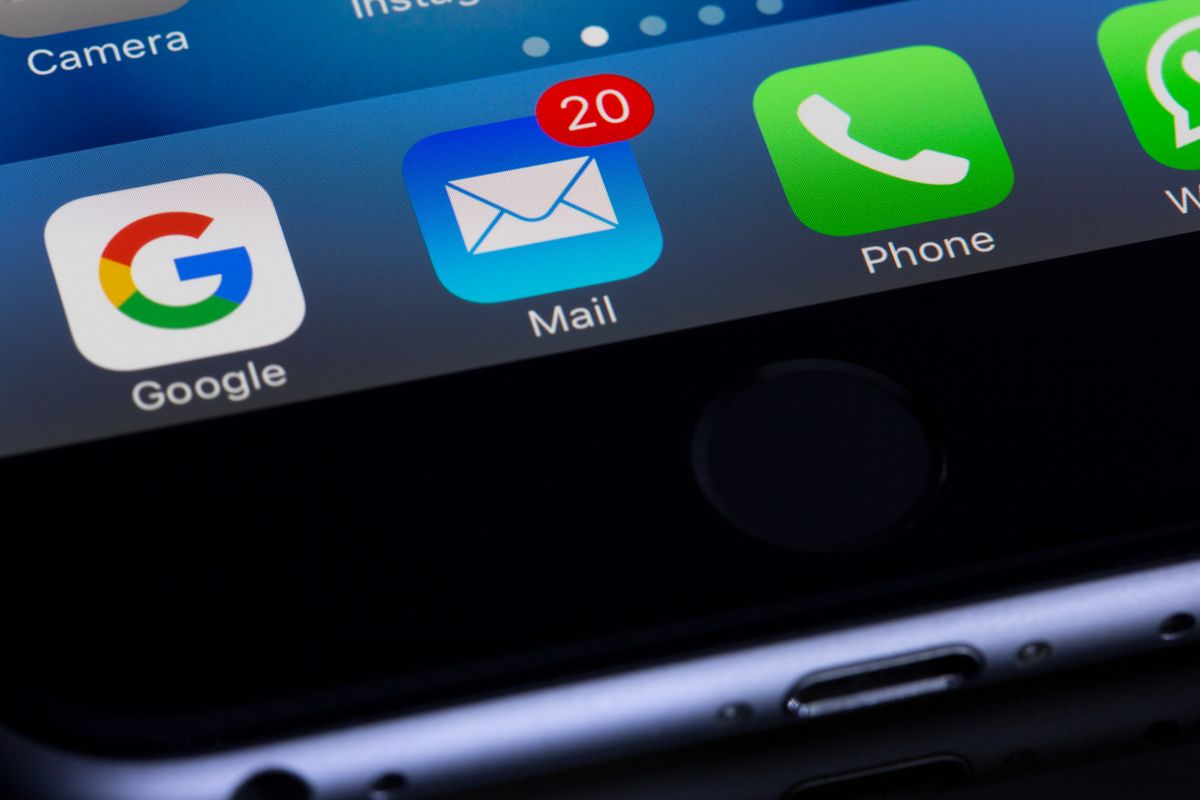Smartphone screen showing email and notification apps representing invitation email delivery
