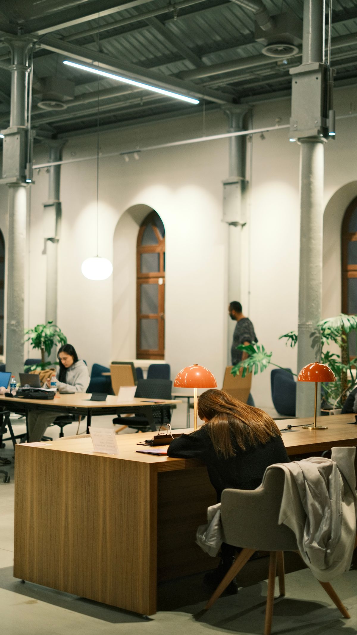 People collaborating in an open, shared modern office space, representing transaction mode sharing a small number of real connections across many concurrent clients