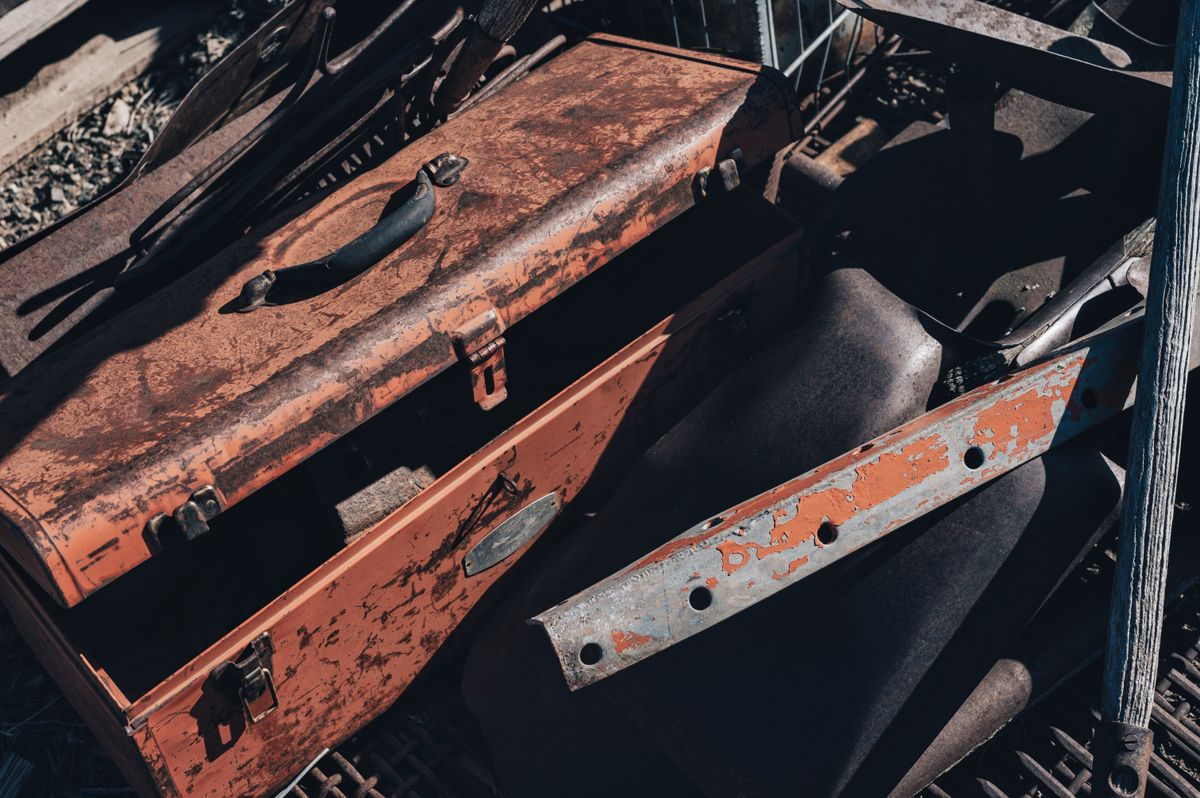 A rusty vintage toolbox sitting among scrap metal, representing a CI environment missing the TypeScript runner the seed command actually depends on