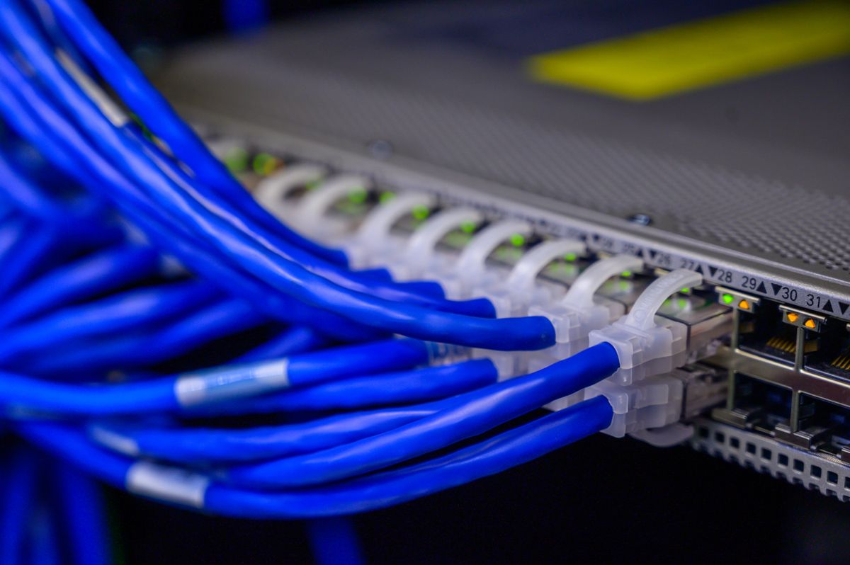 Blue ethernet cables connected to a network switch representing network connectivity for NestJS horizontal scaling