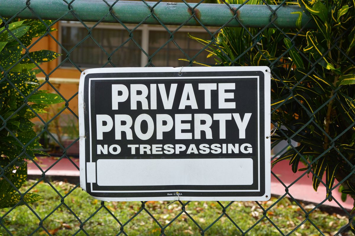 A private property, no trespassing sign on a chain-link fence, representing Railway's private network that requires the correct protocol configuration to actually let traffic through