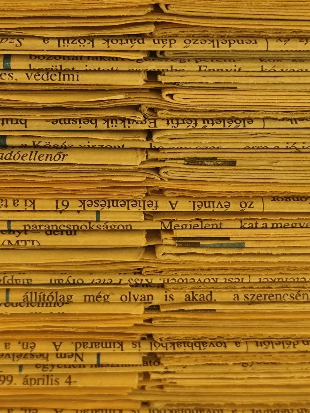 A tightly stacked pile of yellowed, aged newspapers with visible printed text, representing stale generated route types that keep showing the old synchronous signature after an upgrade