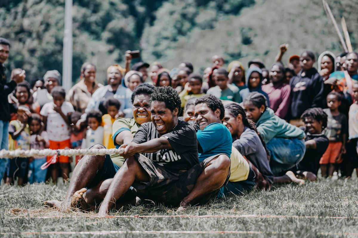 An intense tug-of-war competition with a cheering crowd, representing what a genuine lock conflict between two workers actually looks like — which is far rarer than it first appears