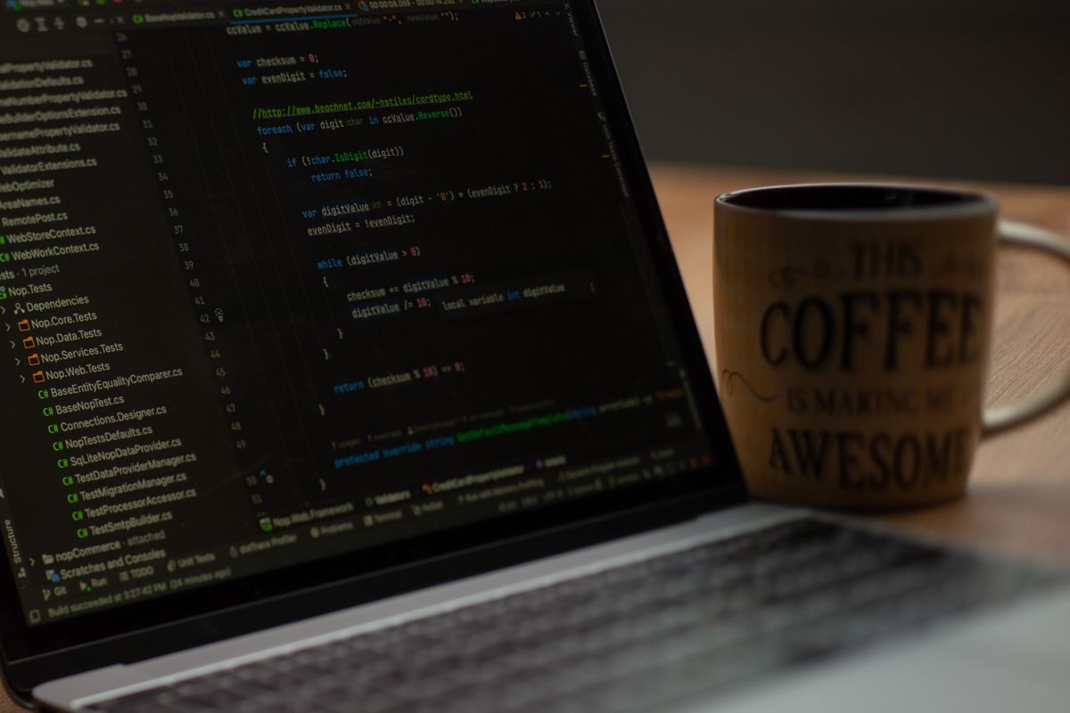 Laptop screen with code and coffee mug representing Java monolith migration development work