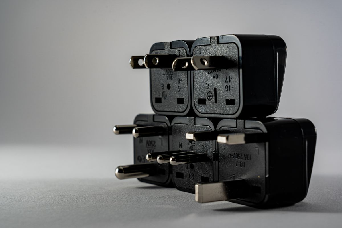 A stack of black international power plug adapters, representing family: 0 accepting either IPv4 or IPv6 rather than assuming only one