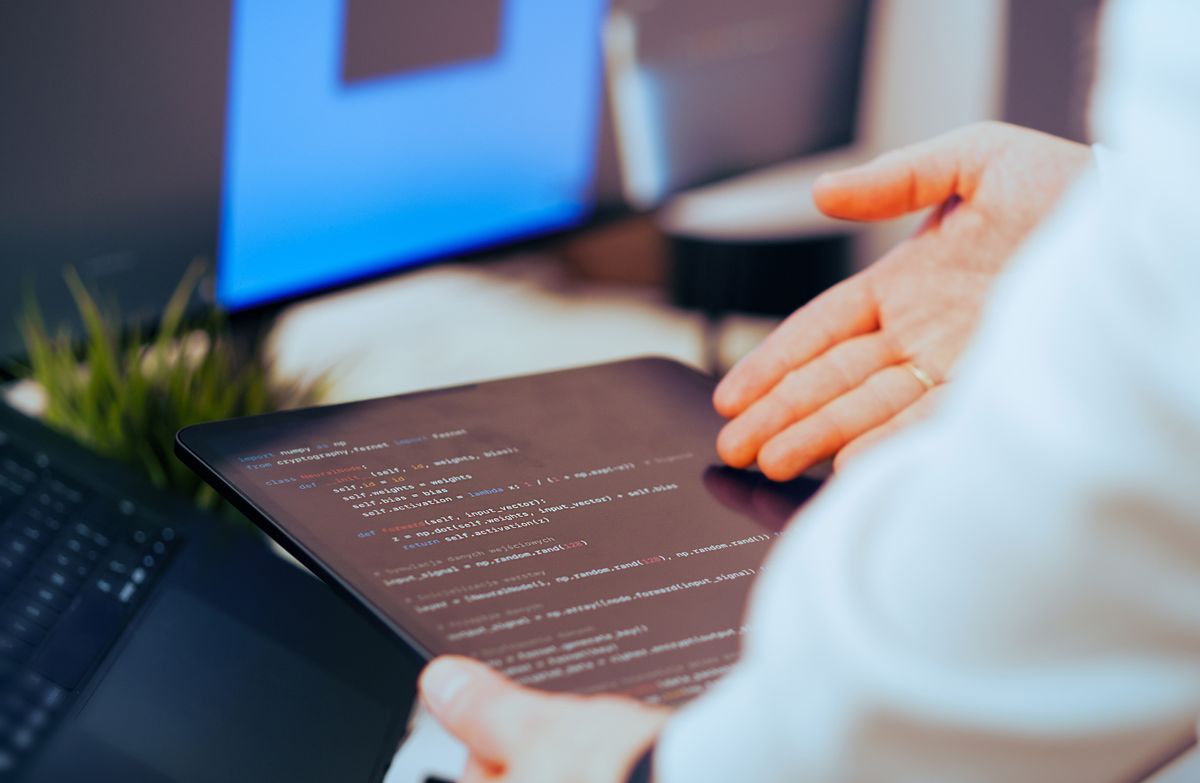 Injection vulnerability code review — software developer analyzing code on a tablet highlighting security review practices