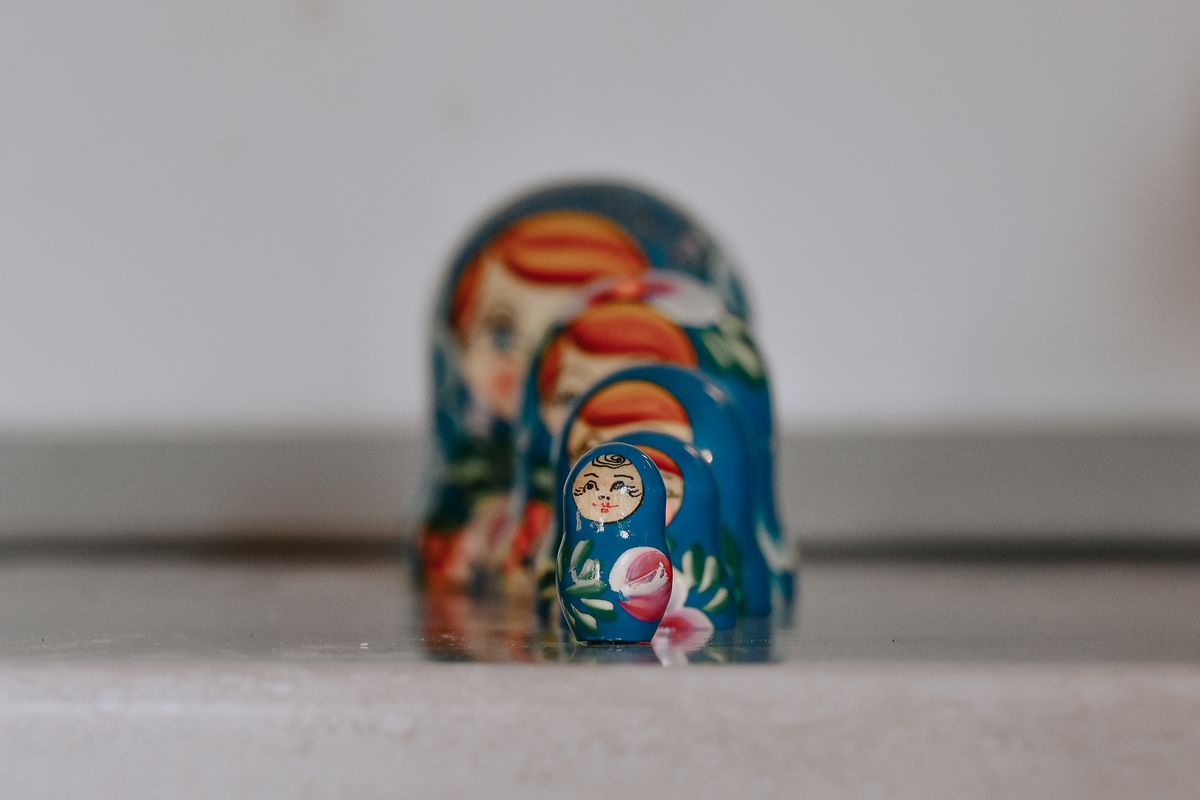A line of Russian matryoshka nesting dolls, each one containing a smaller doll inside it, representing a Server Action hidden inside a library import rather than written directly in your own code