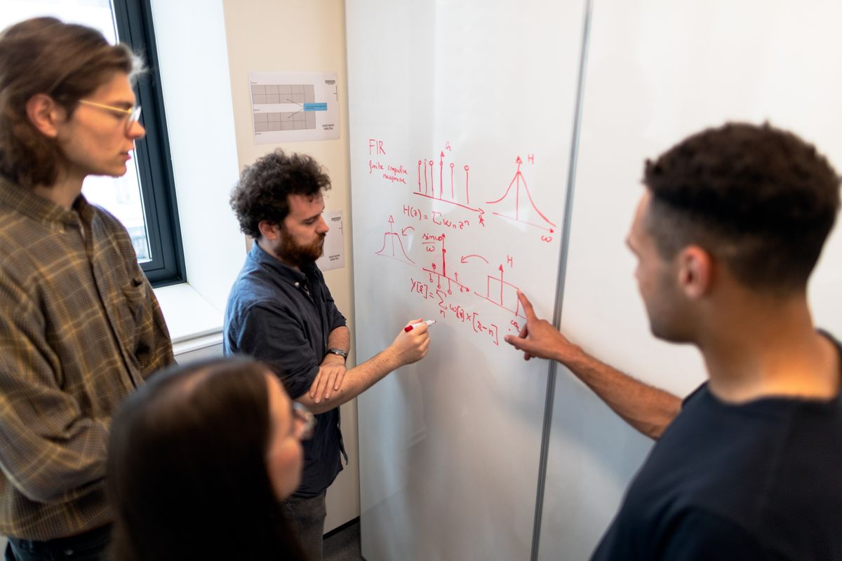 Engineering team at a whiteboard — microservices solve an org-chart problem, not a code problem