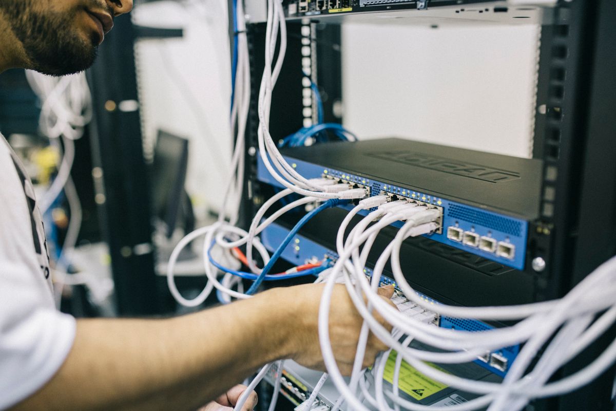 Configuring third-party API integration reliability in NestJS — IT professional connecting network cables in server rack