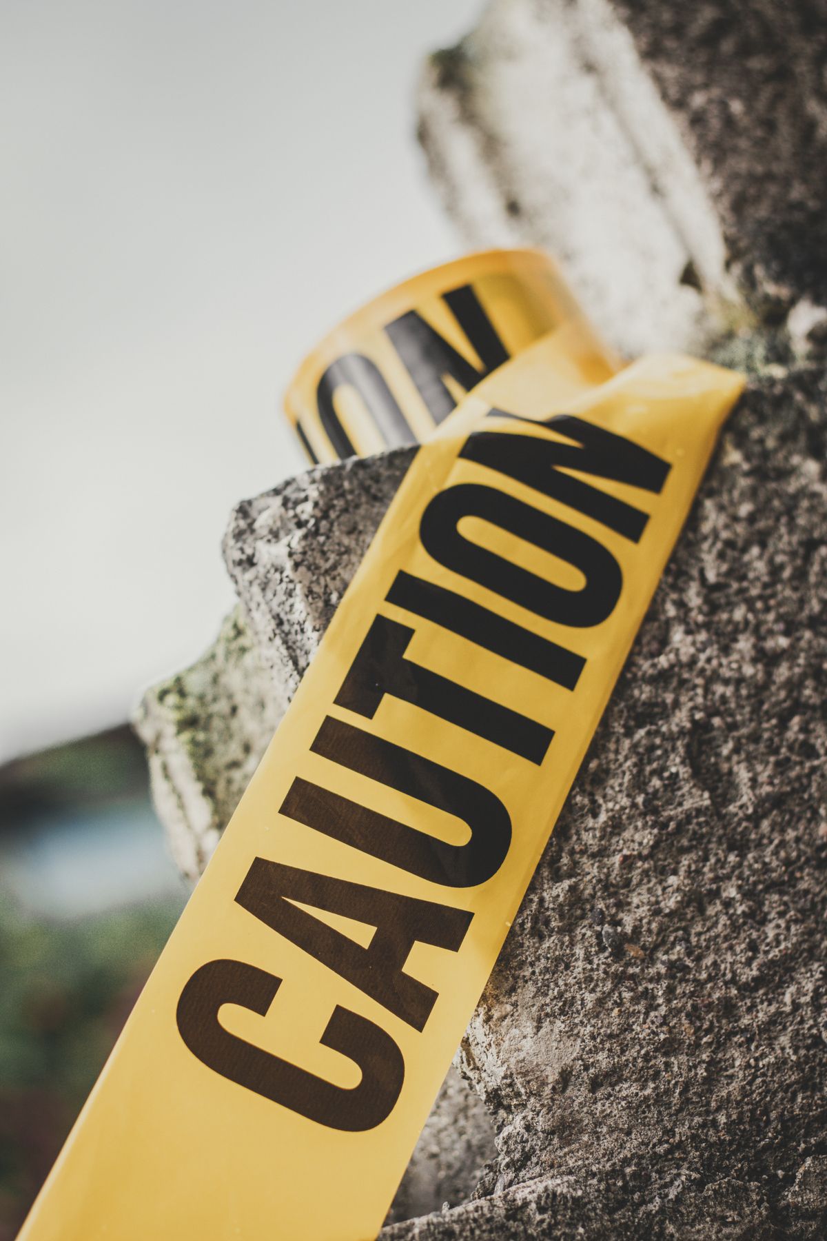 Yellow caution tape stretched across a cement surface with the word 'CAUTION' visible, representing the risk of applying an unlimited-retry setting more broadly than BullMQ actually needs