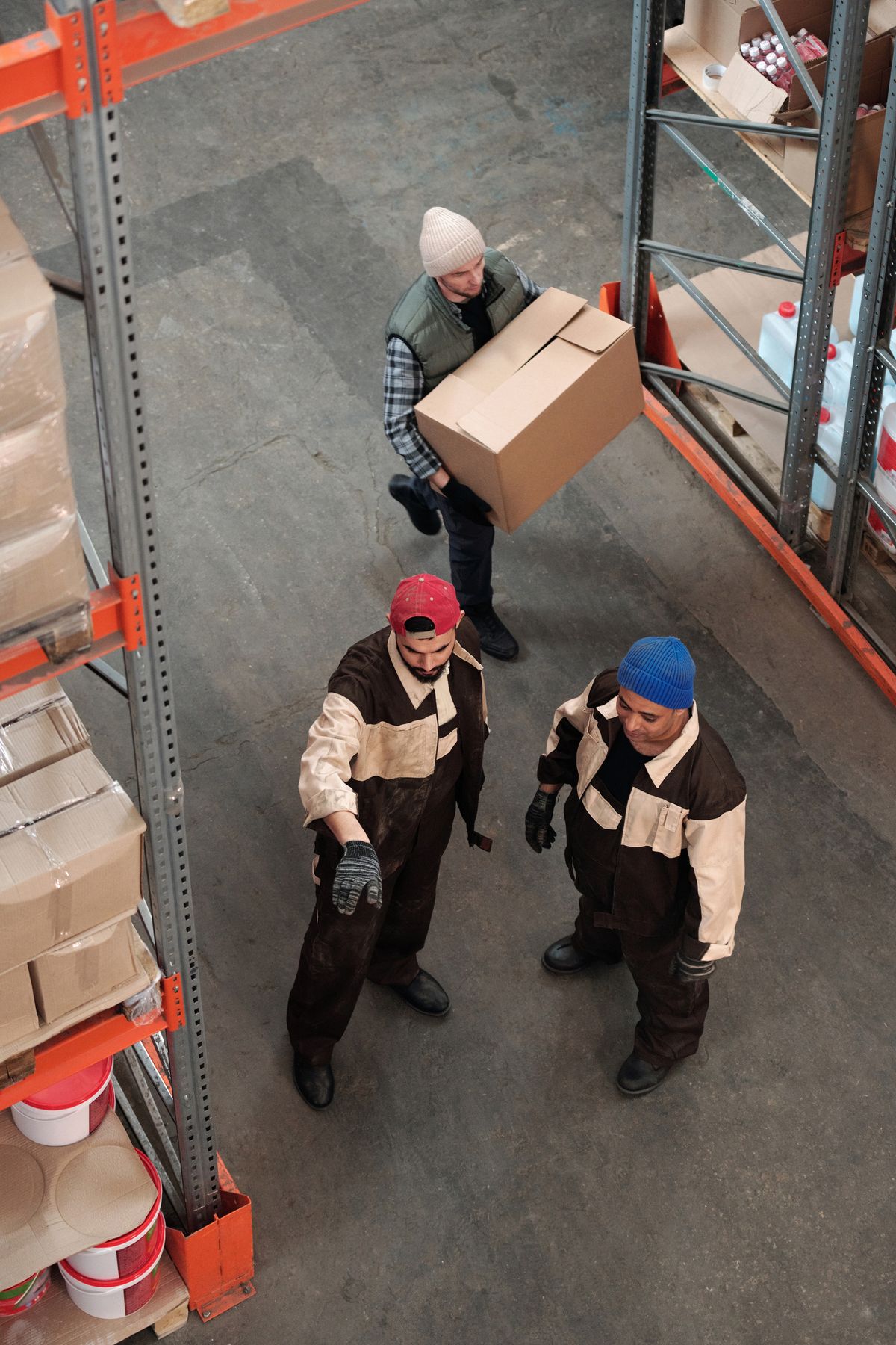A team of workers managing inventory in a warehouse, representing a background job worker that stays on the job continuously