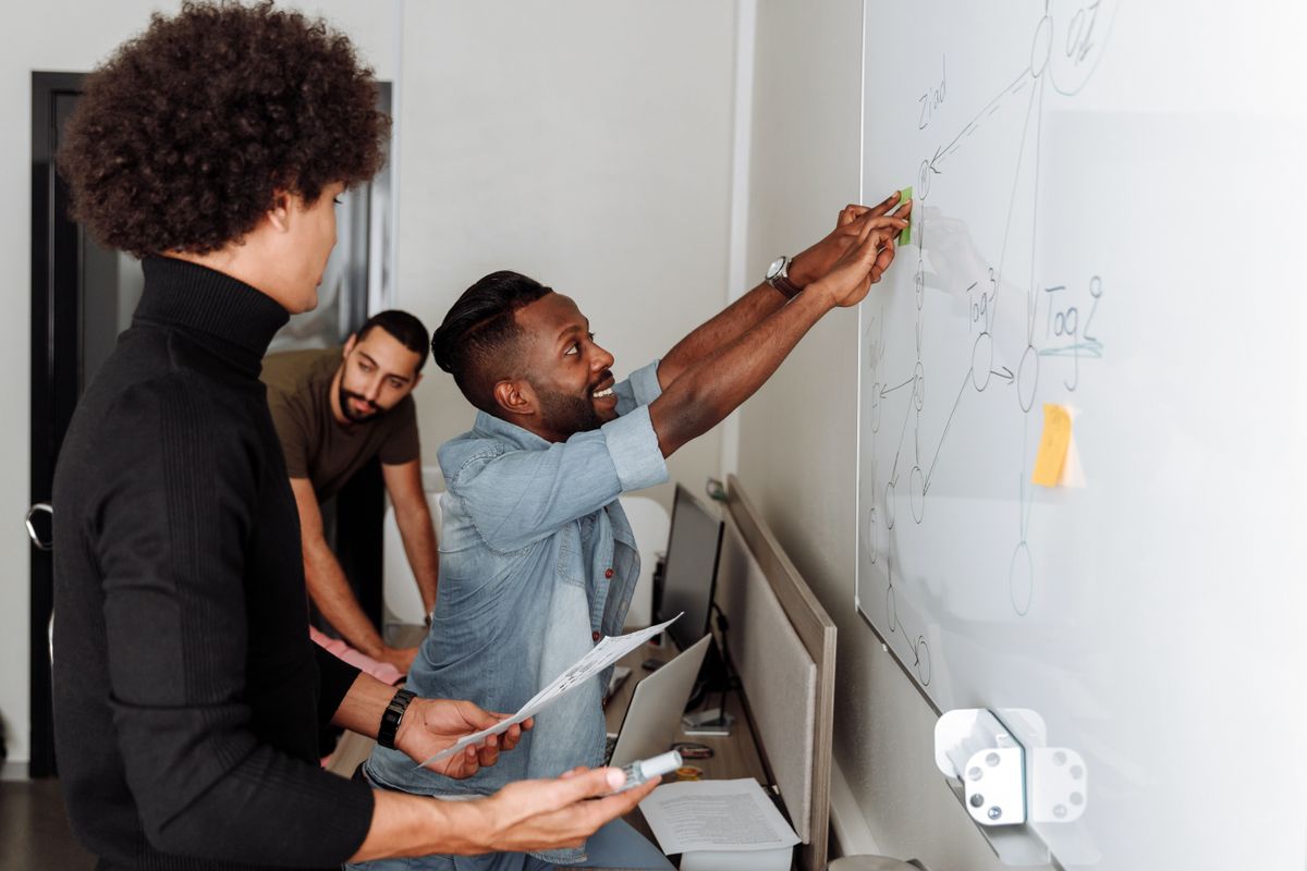 Engineering team mapping out a NestJS modular architecture refactor on a whiteboard
