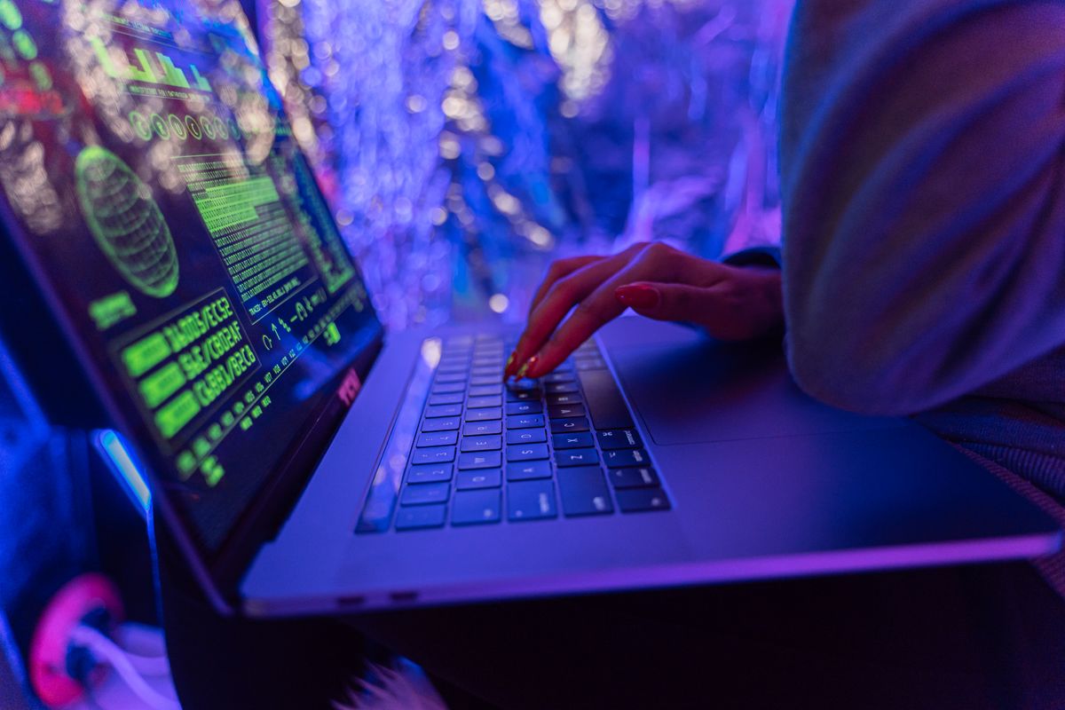 Hands typing on a laptop with cybersecurity graphics, representing secure NestJS JWT refresh token handling