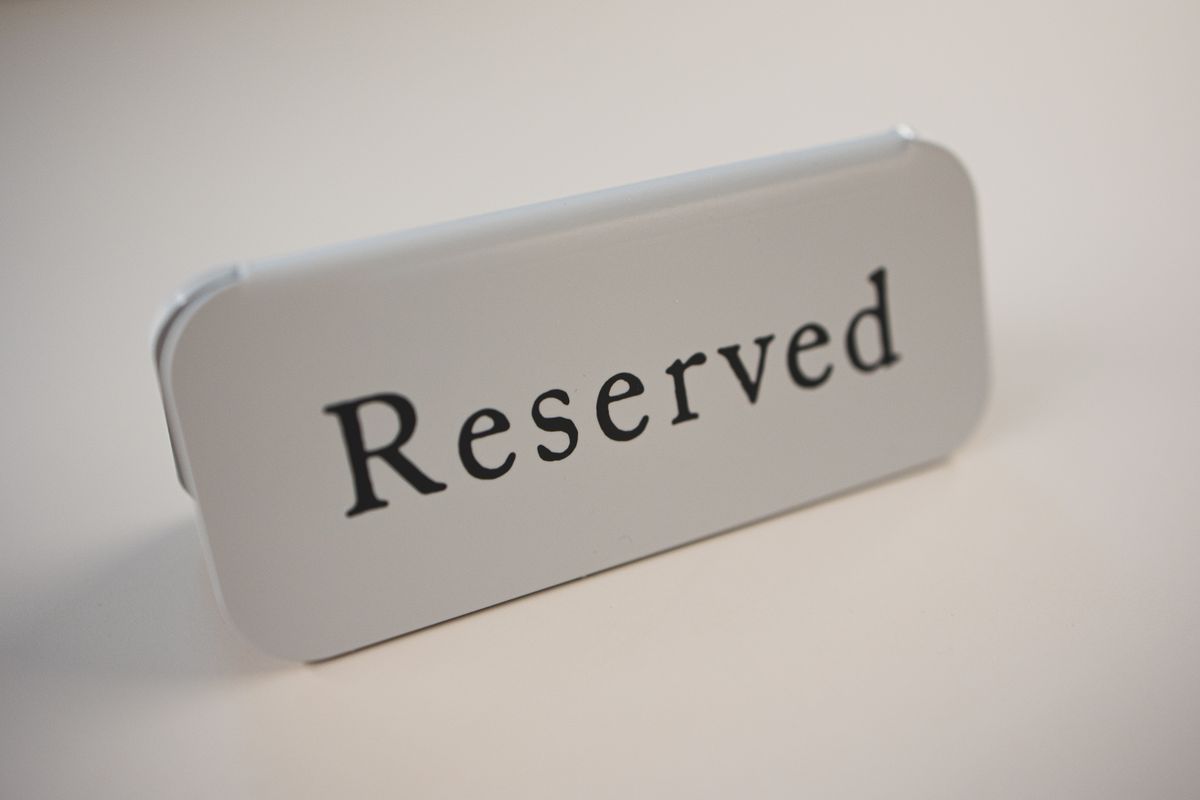 A metal 'Reserved' sign on a restaurant table, representing session mode holding one connection exclusively for a single client rather than sharing it