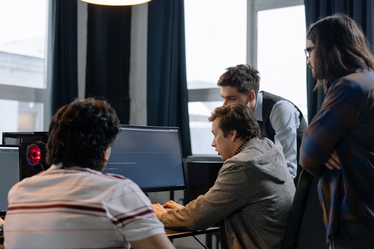 A group of developers working together on a computer programming project, representing a team scaling their queue workers horizontally