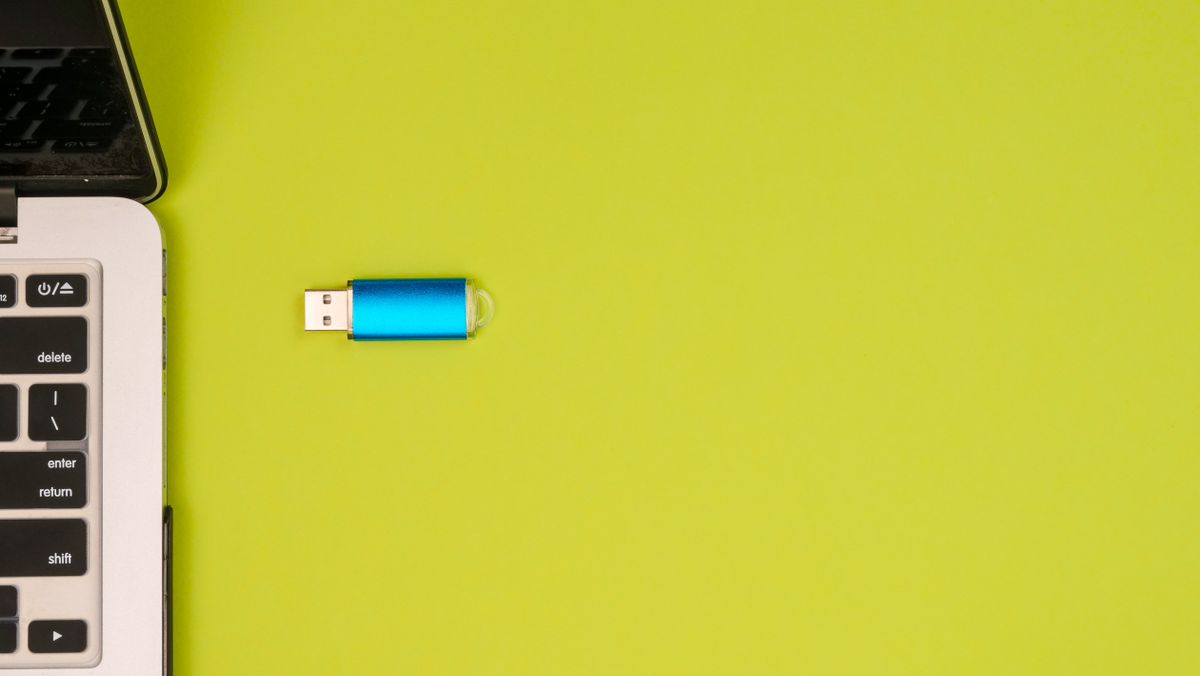 SaaS file upload architecture — a USB drive beside a laptop representing direct file transfer to cloud storage