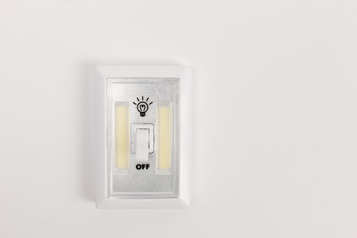 A wall light switch representing a SaaS feature flag toggling a feature on or off at runtime