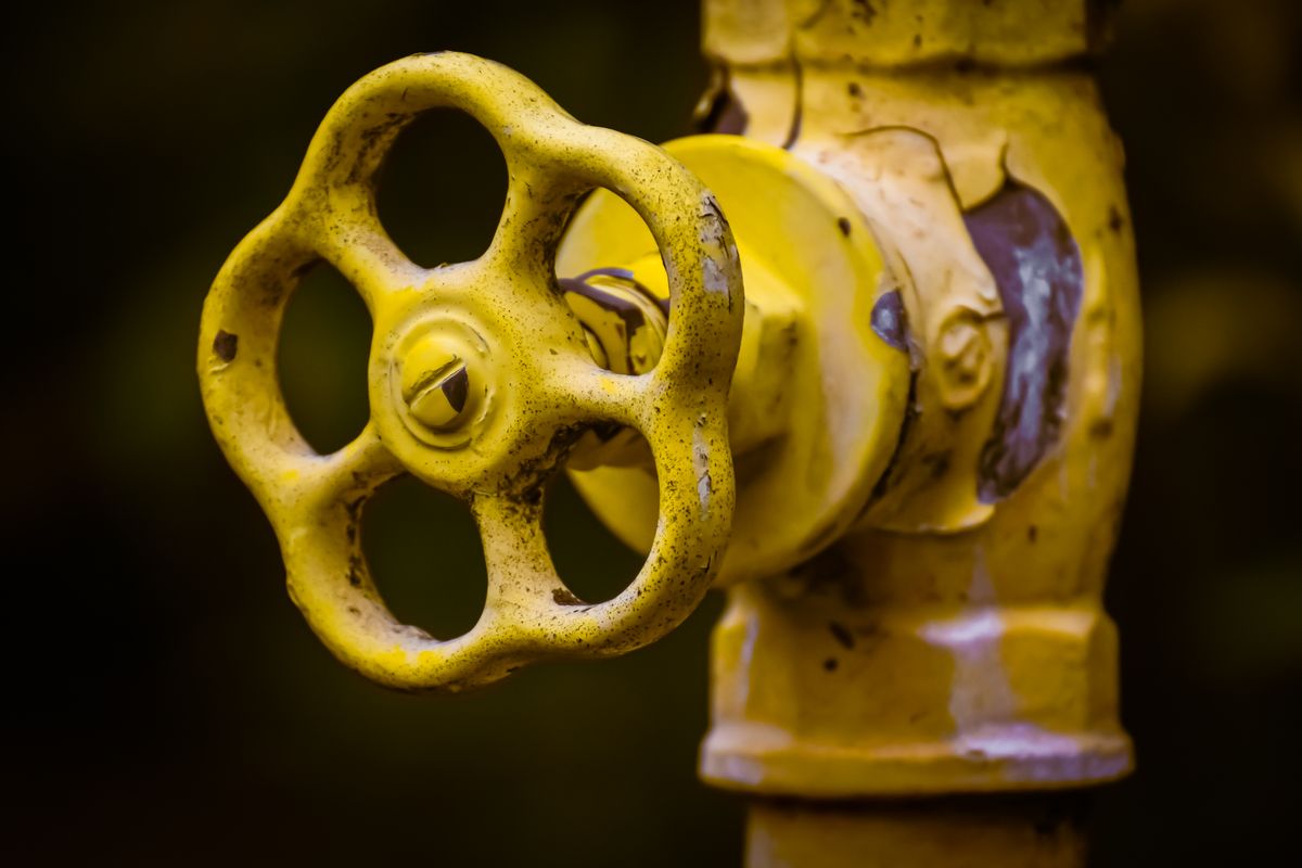 A rusty yellow industrial shut-off valve, representing the direct connection you open specifically to bypass the pooler for migrations