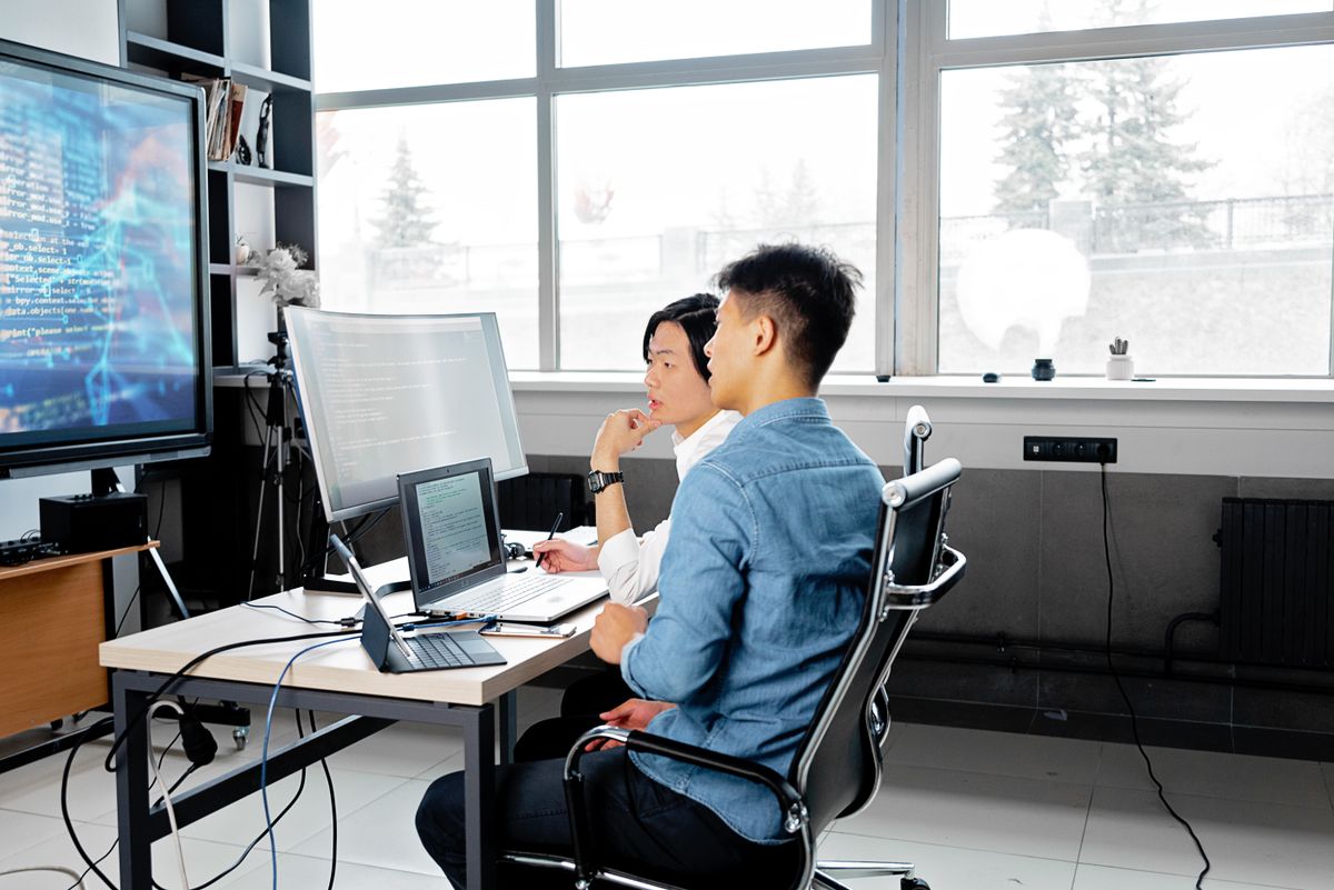 Two engineers reviewing integration tests as part of a SaaS testing strategy