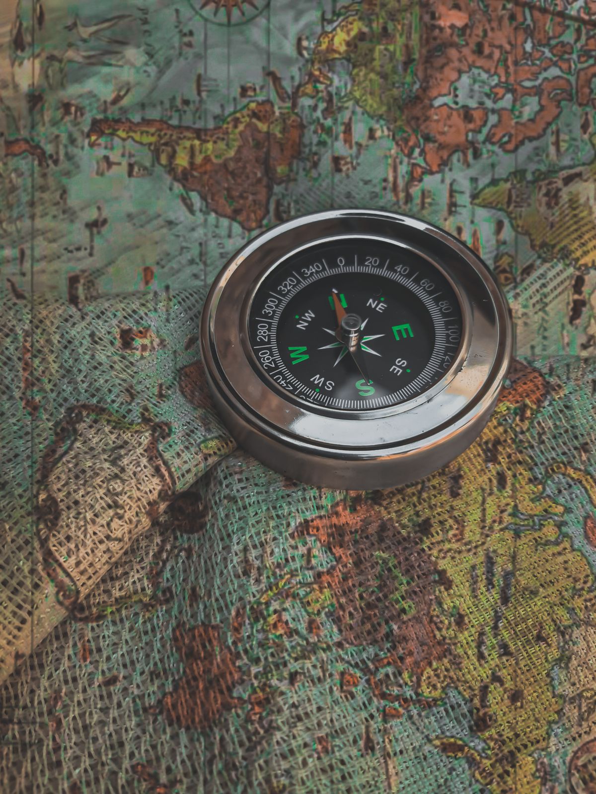 A metal compass resting on a vintage world map, representing a Redis client's stale view of which node is currently the primary after a failover