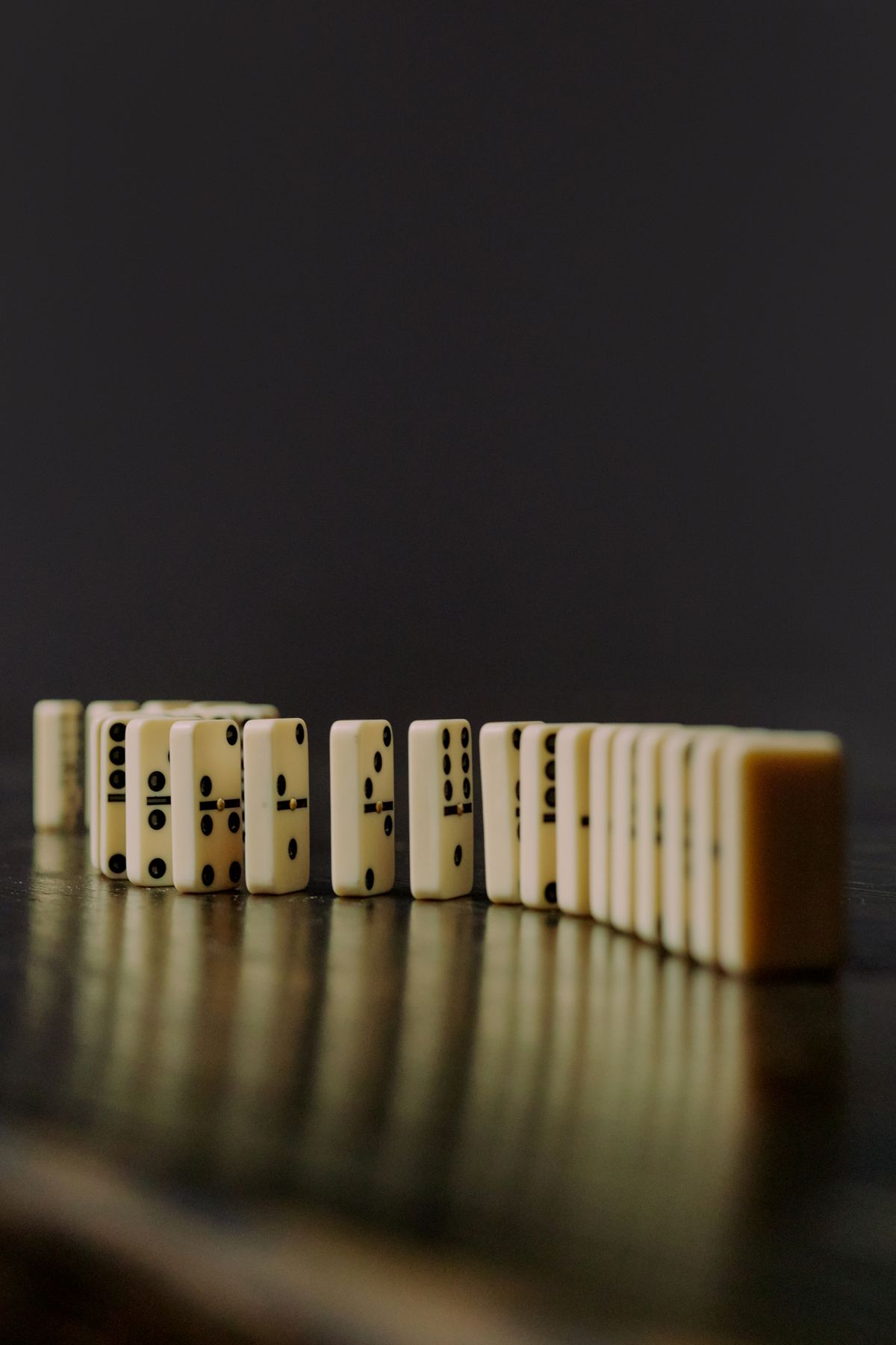 Domino blocks lined up in a precise row, representing seed and migrate steps that need to run in the correct order, not in parallel